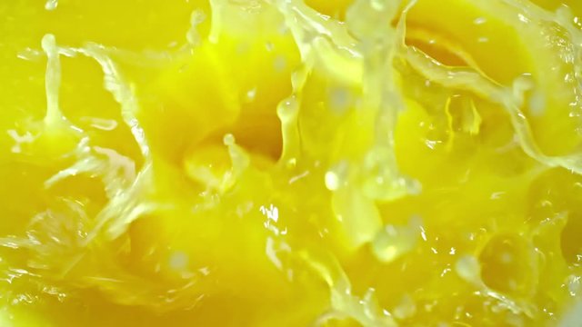 Closeup of unpeeled orange slices falling down and then floating in fleshy juice in slow motion