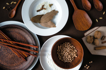 Set of white and brown rustic ceramic dishware with decoration of nuts, rice and green leaves