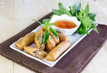 Veg Spring Rolls, on white dish and wooden table
