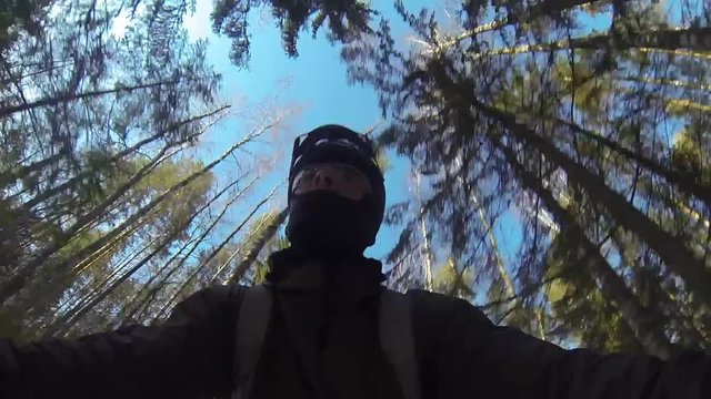 A man mountain biking in the snow forest, view from handlebar