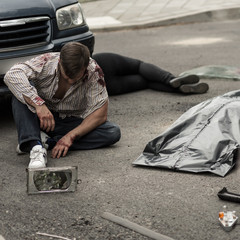 Injured man sitting on the street