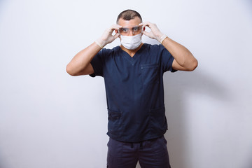 Fototapeta premium Portrait of young doctor with mask on a white background. Concept surgery and healthy