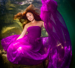 The girl in a dress under water