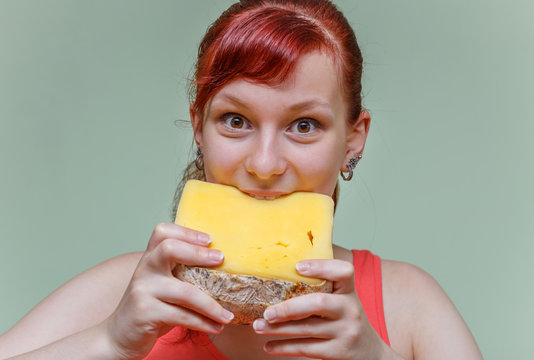 beautiful girl bites cheese cheddar