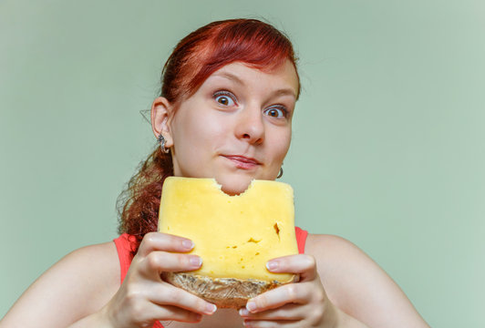 beautiful girl bites cheddar cheese