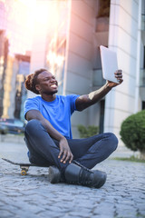 Obraz premium Sitting guy doing a selfie with a tablet