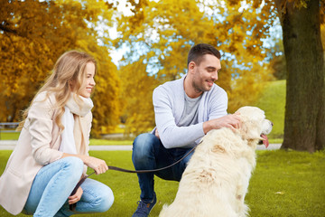 happy couple with labrador dog walking in city