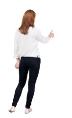back view of standing young blonde business woman showing thumb up. beautiful businesswoman in black suit gesturing ok sign. Rear view people collection.  backside view of person.  Isolated over white