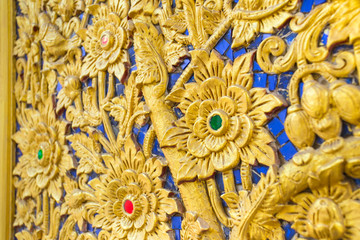 Thai flower pattern emboss woodcraft paint with gold color in temple, Asian style foral antique culture decorative art design handcrafted.
