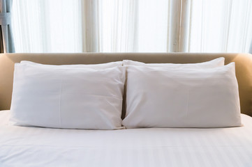Fototapeta na wymiar several white pillows on a white bed