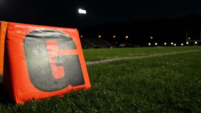 dolly of a goal line "G" on a football field at night time.