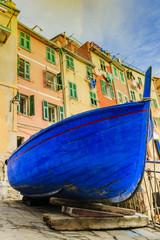 Old blue boat in Riomaggiore one of the five villages of the Cinque Terre on Italy mediterranean coast.