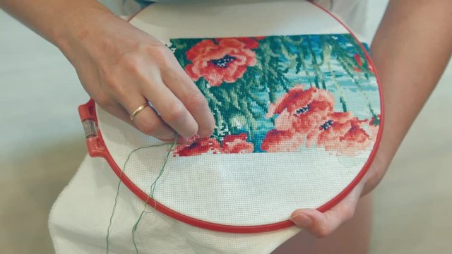 Girl cross stitching pattern with flowers