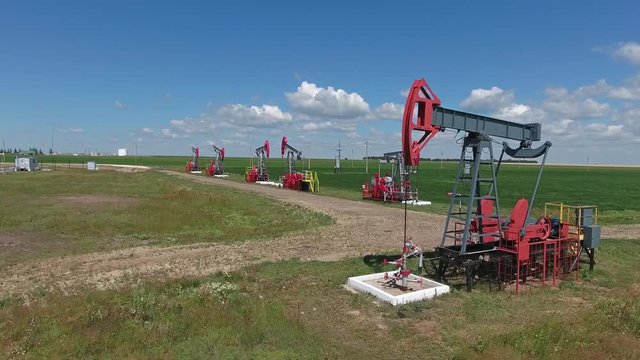 Flying over working oil pumps at sunny day, 4k
