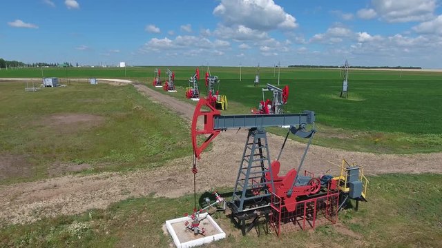 Flying over working oil pumps at sunny day, 4k
