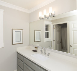 Light bathroom with marble counter top and mirror.