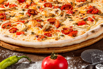 Italian pizza with pepper, cheese at rustic wooden desk 