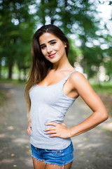 Fototapeta premium Outdoors portrait in park of a beautiful tanned teen student girl.