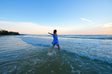 Fototapeta na wymiar Asian girl running toward water