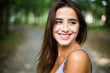 Outdoors portrait in park of a beautiful tanned teen student girl.