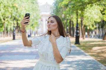 beautiful girl on the background of the city photographed themselves on the phone