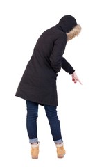 Naklejka premium Back view of pointing young women in parka. Young girl gesture. Rear view people collection. backside view of person. Isolated over white background. 