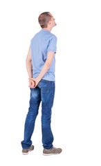 Fototapeta premium Back view of young man in t-shirt and jeans looking. Standing young guy. Rear view people collection. backside view of person. Isolated over white background.