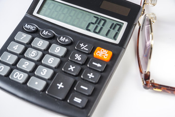 Calculator and eyeglasses on white background