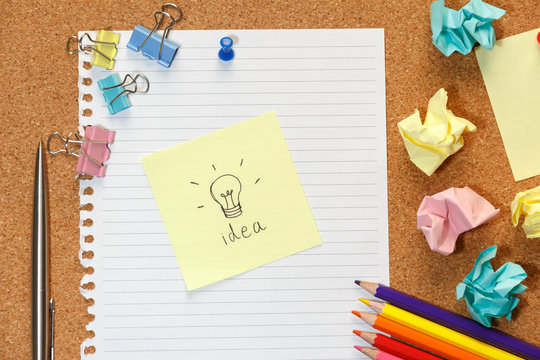 Cork board with Idea wording on paper, colorful blank notes