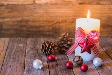 Fototapeta na wymiar Christmas background with natural decoration and burning candle on wood