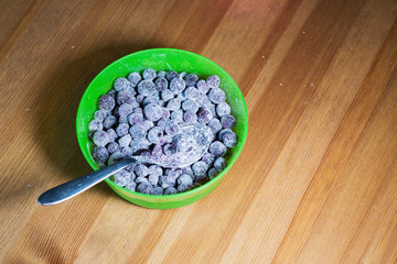 Baking muffins ingridients. Blueberries in a green bowl on wooden table background