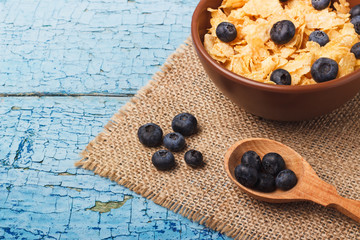 Portion of corn flakes in the bowl with blueberries