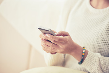 Cropped image of woman reading message on her phone