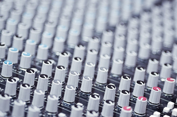 Obraz premium Closeup mixing faders and knobs as seen from above side angle, artistic studio equipment concept
