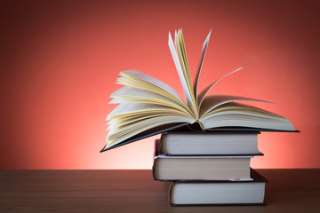 Libro aperto su pila di libri chiusi