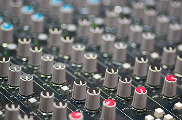 Obraz premium Closeup mixing faders and knobs as seen from above side angle, artistic studio equipment concept