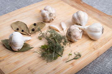 Wooden board with garlic and dried spices closeup