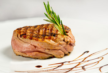 steak, grilled with a sauce. Serving on a white plate