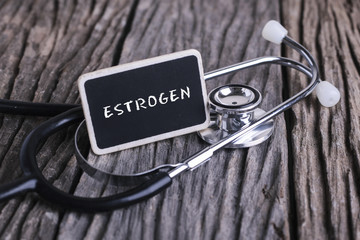 Medicine concept. Blackboard with word ESTROGEN and stethoscope on wooden background