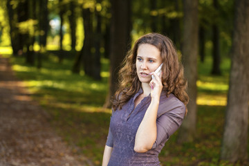 Fototapeta premium Portrait of beautiful dark haired young woman speaking on mobile