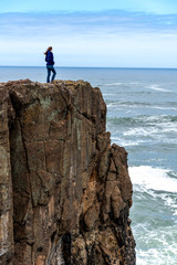 Obraz premium Powerful woman on cliff of rocks