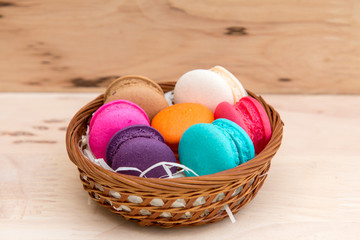 Colorful  macaroons in stack on light wooden background