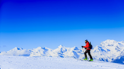 Ski touring in high mountains in fresh powder snow in sunny day. Snow mountain range. Mt Fort Peak Alps region Switzerland.Wallis
