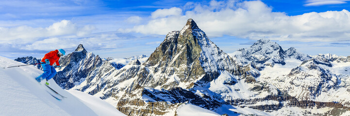 Full length of turn man skiing on fresh powder snow with Matterhorn in background in Swiss Alps. - obrazy, fototapety, plakaty
