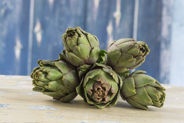 Ripe green artichokes isolated on blue background