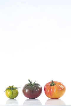 Three heirloom tomatoes on white