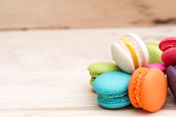 Colorful  macaroons in stack on light wooden background