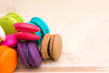 Colorful  macaroons in stack on light wooden background