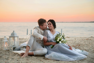Young couple in love outdoor. Young bride and groom posing at sunset on the beach. young couple on the beach. young couple relaxing at sunset. young couple relaxing on the beach