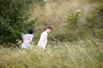 Young couple in love outdoor. Elegant bride and groom posing together outdoors on a wedding day. bride and groom in the Park. young couple in the woods. young couple in the grass. couple walking